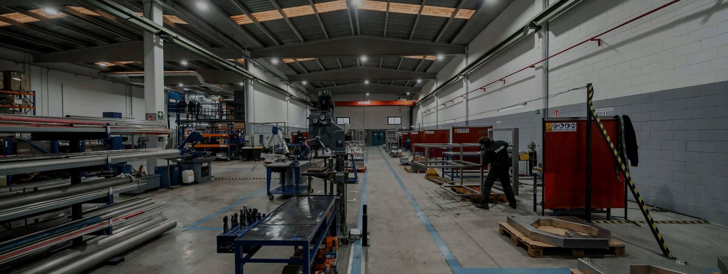 Sheet metal shop: bar racks, drill press, welding booths and an operator connected to ISI®